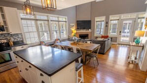 A spacious kitchen with a central island, white cabinetry, and a large window. - Near Indiana Dunes w/ pool, tennis court, golf cart (Michigan City)