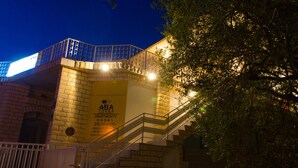 Un immeuble avec une enseigne indiquant « ABA Apartments & Rooms Excursions » et un escalier menant à un étage supérieur.