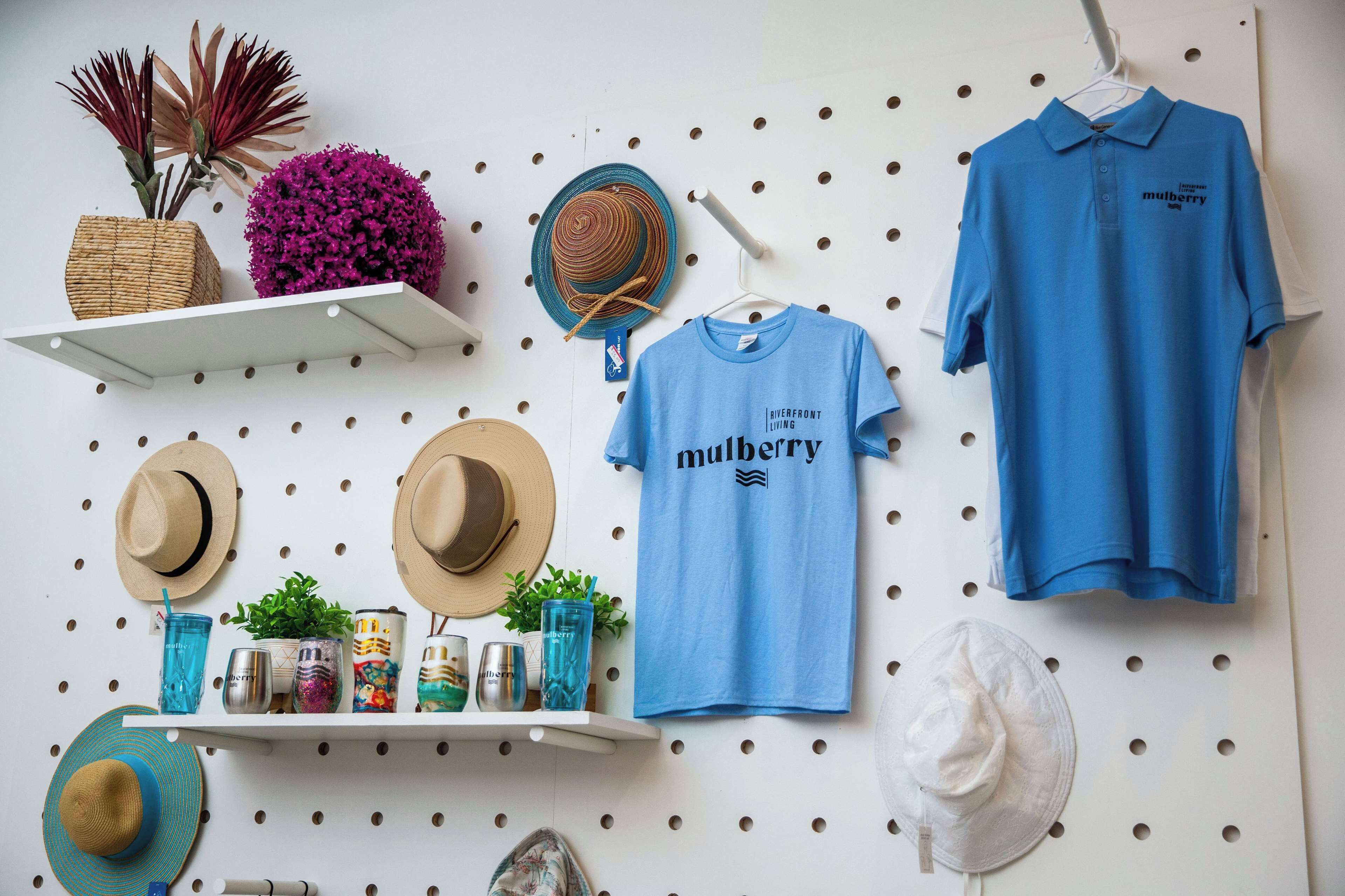 Pared amb diversos objectes, com barrets, una camisa blava i ornaments decoratius.