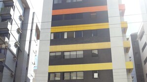 Um edifício de vários andares com design moderno, combinando branco, preto e amarelo.