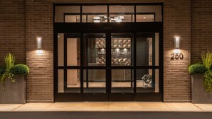A hotel entrance with a glass door, a brick facade, and the number 250 on the right.