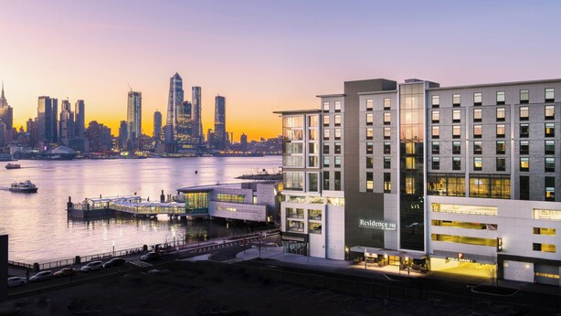 Un hôtel moderne offrant une vue sur les gratte-ciel de la ville et situé au bord de l’eau.