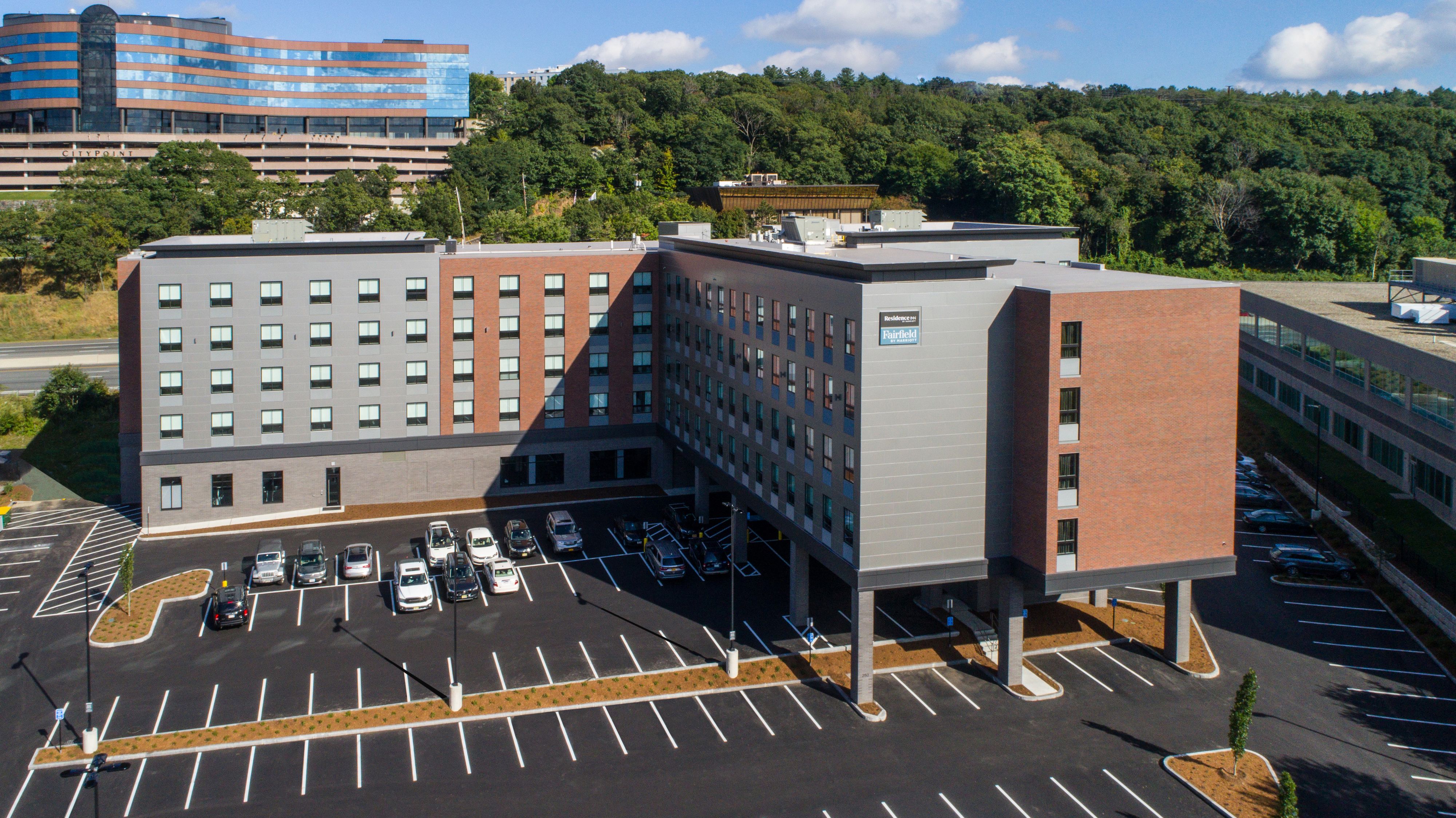 A multi-story hotel with a parking lot in front.
