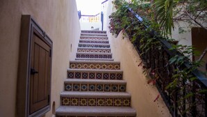 Un escalier étroit, orné de carreaux aux motifs complexes, menant à un niveau supérieur.