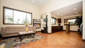 Amplia sala de estar con sofá, mesa de centro y un ventanal grande.