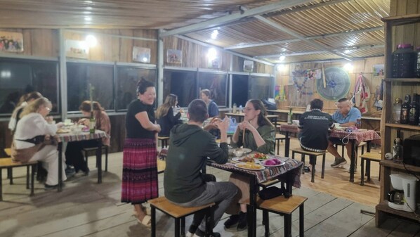 A restaurant with wooden interiors, tables, and chairs arranged for dining.