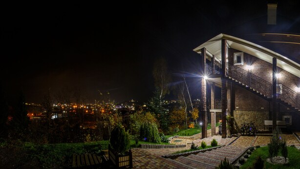 A multi-story building with a staircase, outdoor lighting, and a view of a cityscape at night. - FAVAR Carpathians (Skhidnytsia)