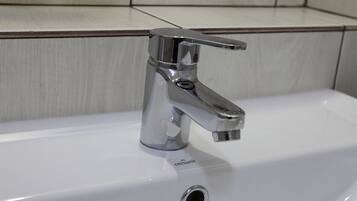Un lavamanos moderno con grifo cromado y un desagüe.