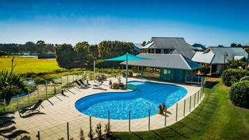 Una piscina al aire libre, sillones reclinables de piscina