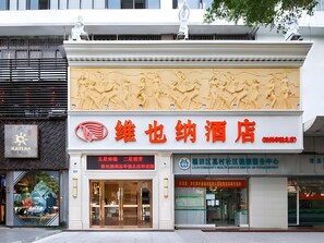 A hotel facade with a large relief sculpture above the entrance. - Vienna Hotel (Shenzhen)