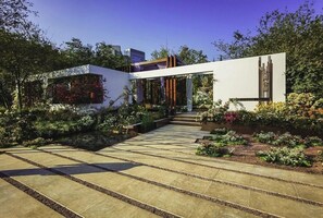 A modern building with a garden pathway leading to the entrance.