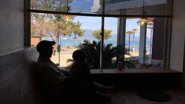 A room with a large window overlooking a beach and a playground. - View Lodge Biwa (Otsu)