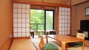 A traditional Japanese room with tatami flooring, a low wooden table, and a sliding door leading to a balcony. - Yamanakako Garden Villa (Yamanakako)