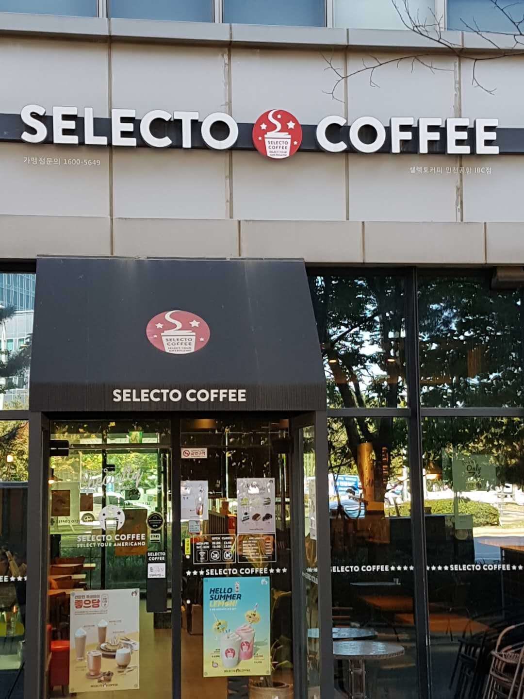 The exterior of a coffee shop named Selecto Coffee with a modern storefront and glass windows.