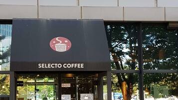 The exterior of a coffee shop named Selecto Coffee with a modern storefront and glass windows.