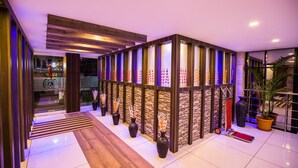 Eine moderne Lobby mit einer Holzwand, Blumentöpfen und einem roten Teppich.