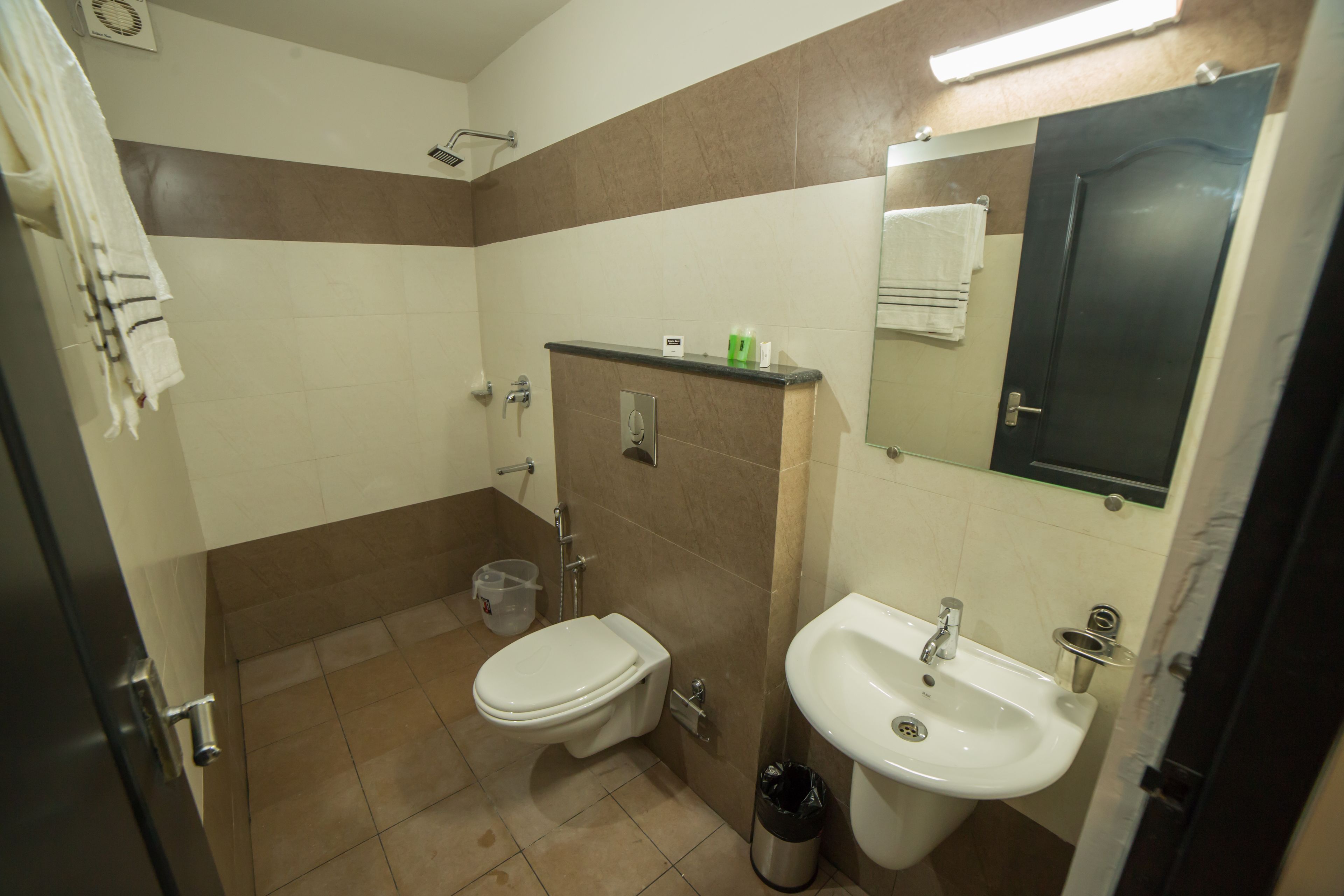 Un baño con inodoro, lavamanos y espejo.