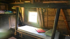 A rustic wooden room with a single bed, a window, and a wooden ceiling. - Ramons Native Homestay and Restaurant (Banaue)