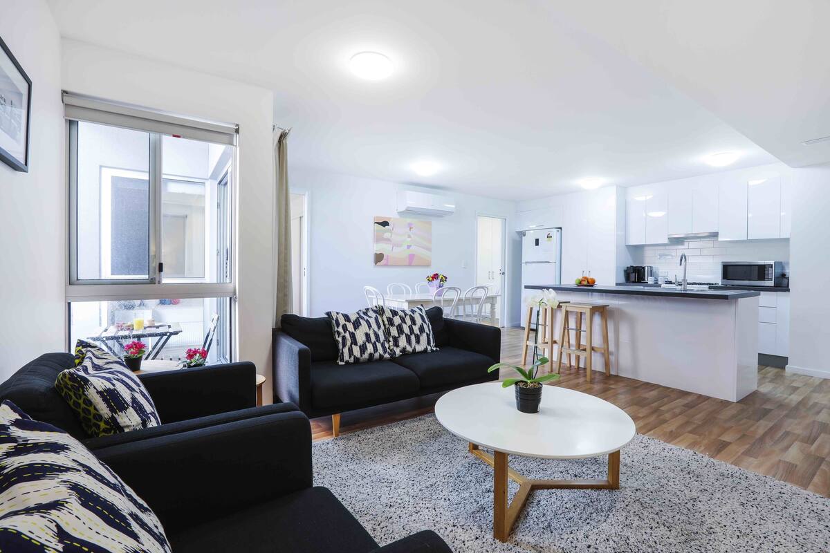 A modern apartment with a living room, kitchen, and dining area.