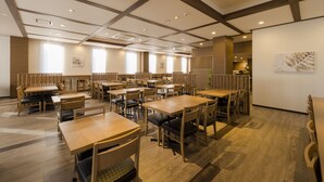 A spacious dining area with multiple tables and chairs, wooden flooring, and a high ceiling with recessed lighting. - Hotel Route-Inn Utsunomiya Yuinomori -Lightline Yuinomori Nishi- (Utsunomiya)