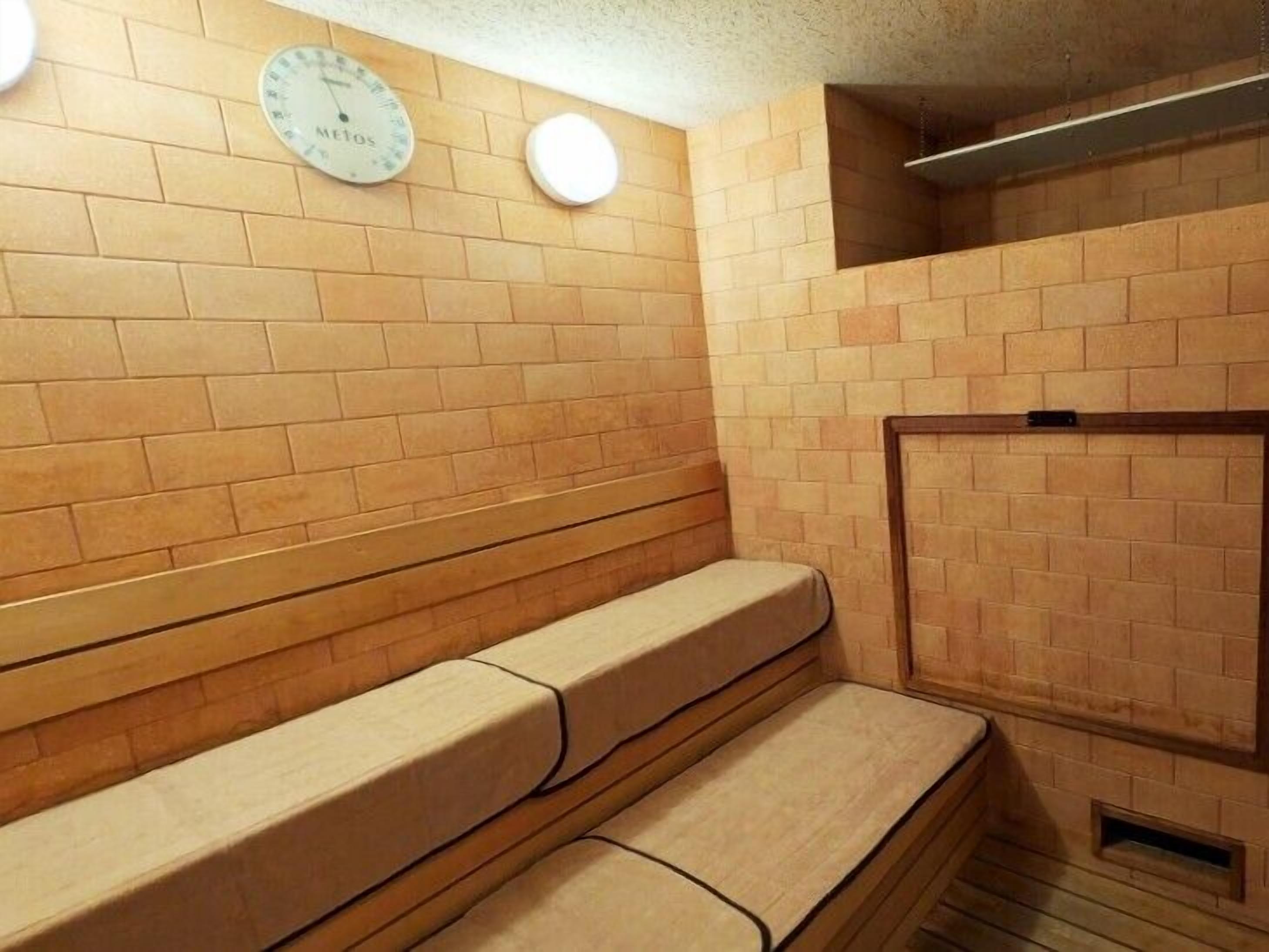 Un sauna avec des bancs en bois et une horloge au mur.
