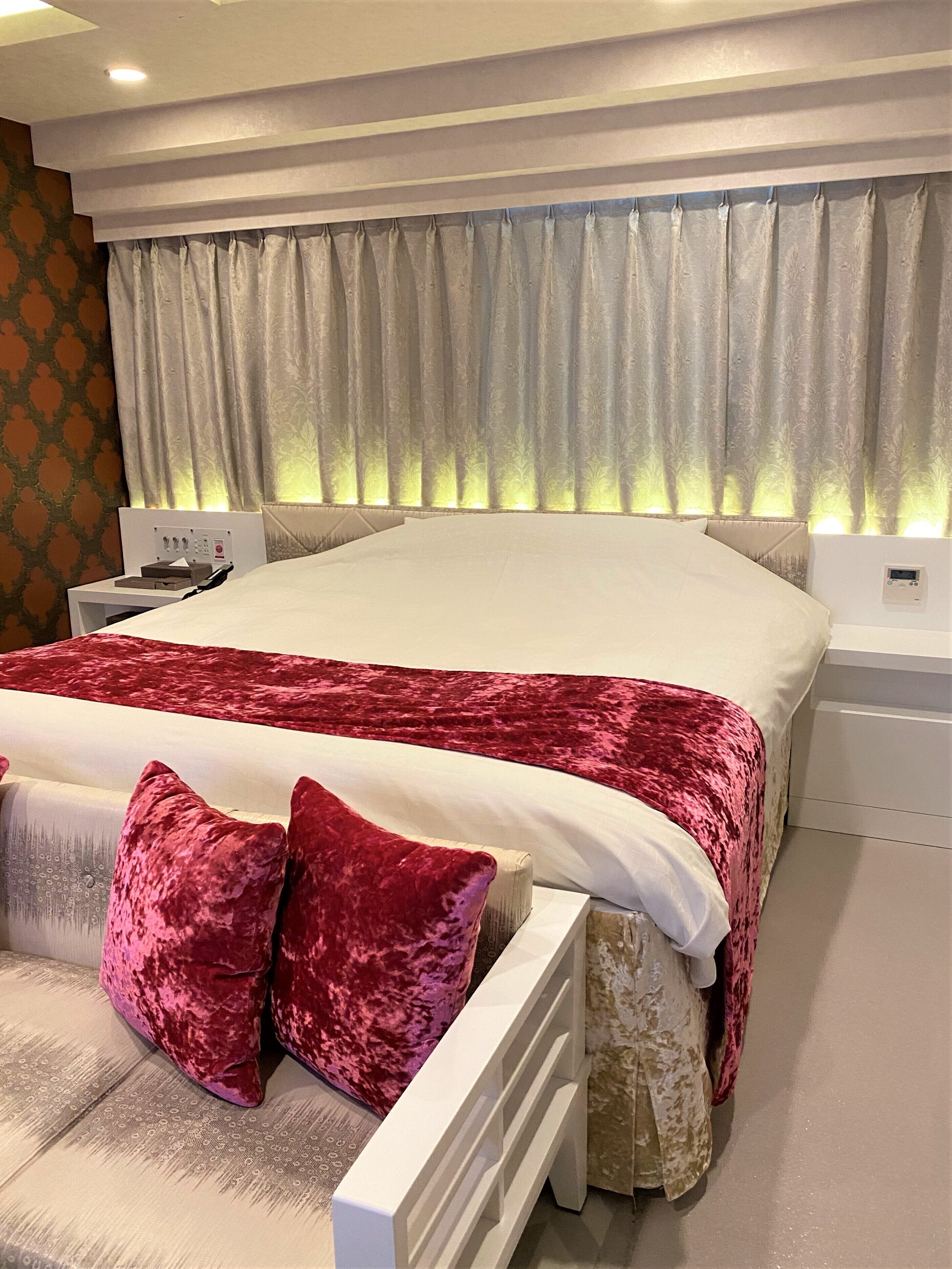 A modern bedroom with a large bed, a bedside table, and a nightstand.