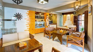 A modern cafe with wooden furniture, a coffee machine, and a menu board. - Hotel Lotus Gems (Kathmandu)