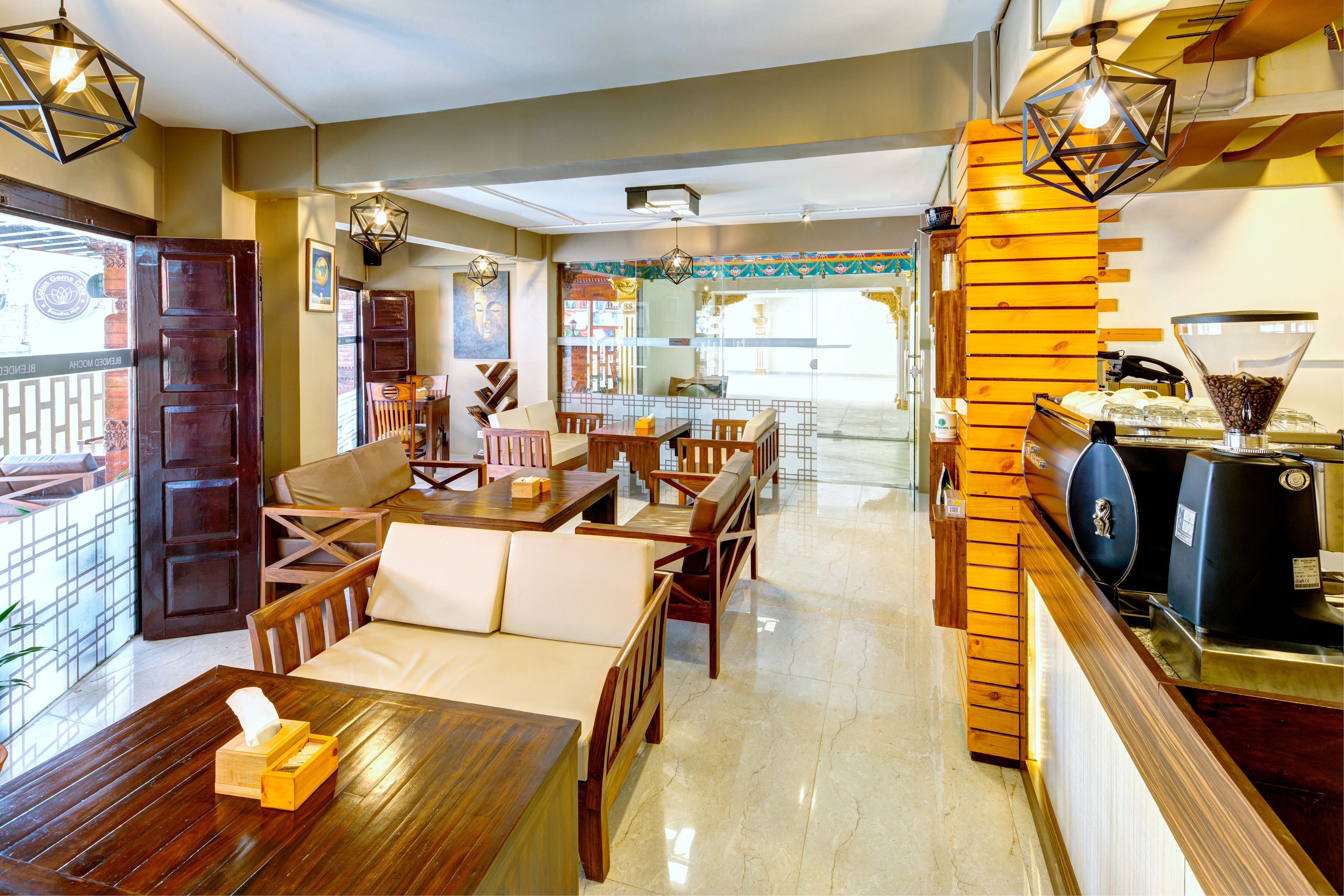 Un restaurant avec des meubles en bois, une machine à café et des lampes suspendues.