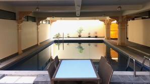 A pool area with a table and chairs, surrounded by ornate columns and a decorative ceiling. - Hotel Lotus Gems (Kathmandu)