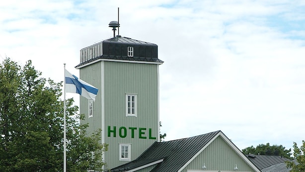 Un hotel con una torre destacada y un cartel que dice "HOTEL" en el costado.