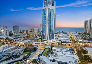 A high-rise hotel with a modern design, located in a coastal cityscape with a view of the ocean. - Circle on Cavill - Q Stay (Surfers Paradise)