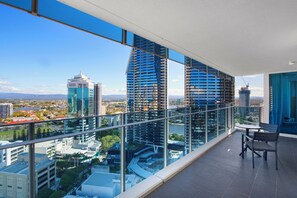 A modern high-rise building with a glass balcony overlooking a cityscape. - H'Residences - Q Stay (Surfers Paradise)