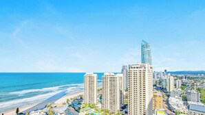 A coastal cityscape with high-rise buildings, including a prominent Novotel hotel, and a beach.