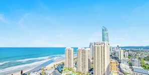 A coastal cityscape with high-rise buildings, a beach, and a clear sky. - H'Residences - Q Stay (Surfers Paradise)