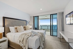 A modern hotel room with a large bed, a desk, and a balcony with a city view. - Soul - Q Stay (Surfers Paradise)
