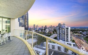 Un balcón con vistas a la ciudad, edificios modernos y cielo despejado.