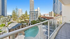 Un hotel moderno de gran altura con piscina en la azotea y vistas a la ciudad.