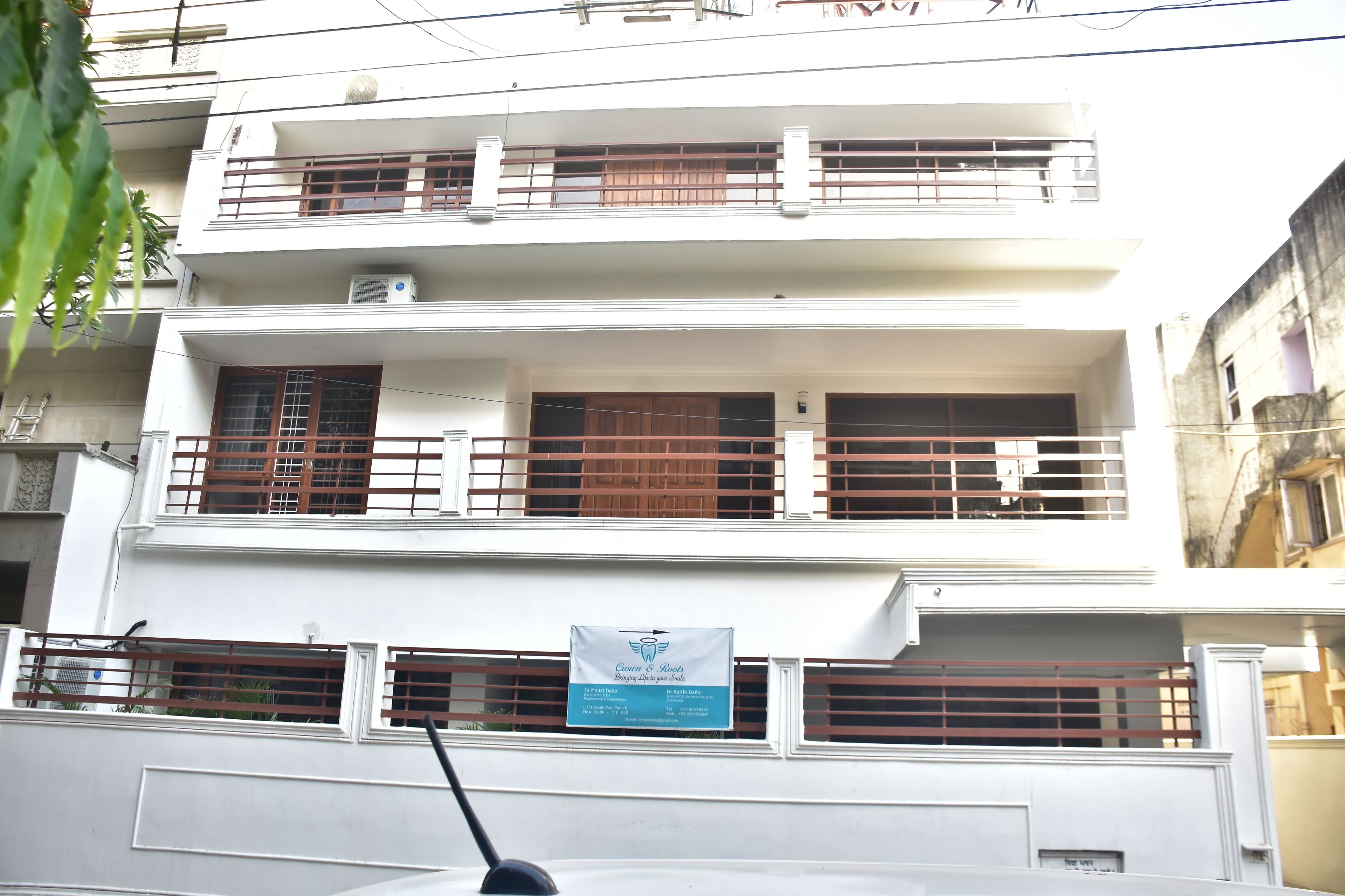 A multi-story building with balconies and a signboard.
