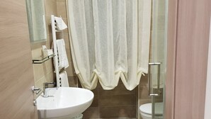 A bathroom with a sink, toilet, and shower area. - La Suite (Cassino)