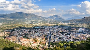 A panoramic view of a city with a dense urban area, surrounded by mountains and greenery. - La Suite (Cassino)