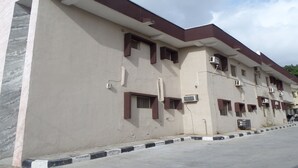 A multi-story building with a flat roof, several windows, and air conditioning units. - Chinox Guest Inn (Abuja)