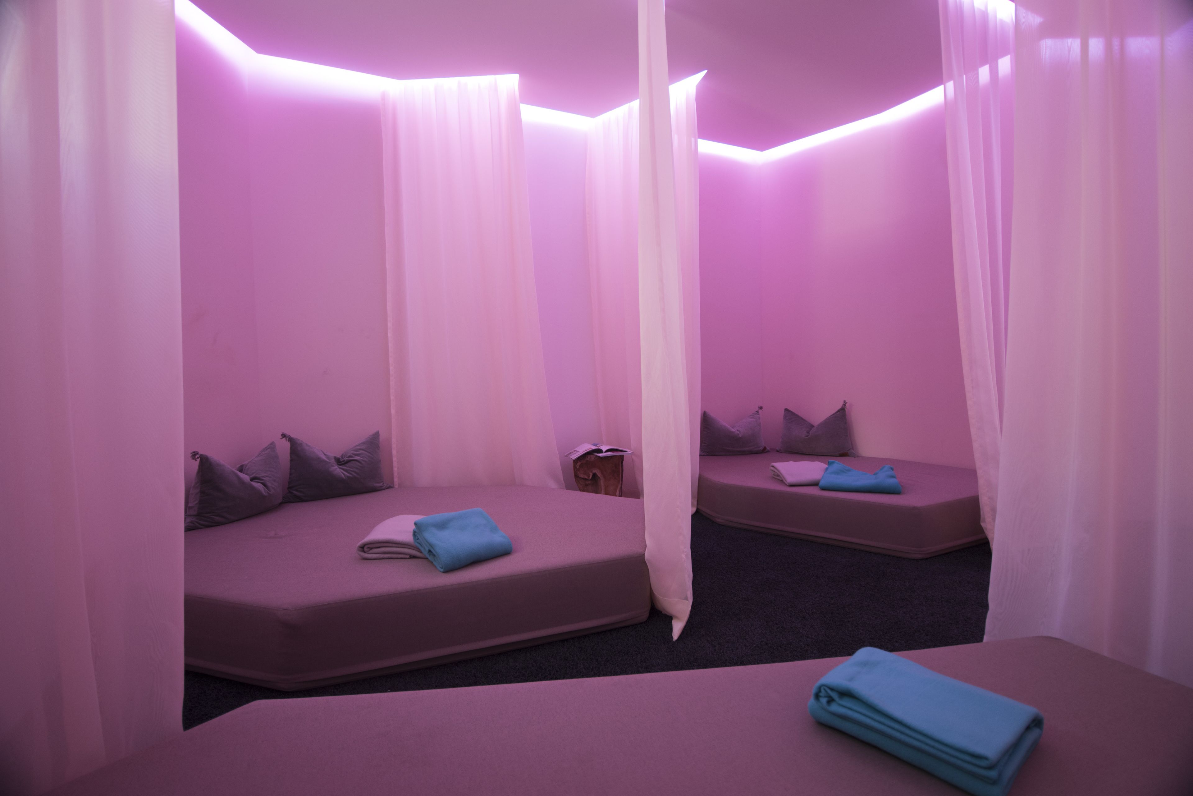 A room with two beds, each with a pillow and a folded towel.