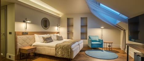 A bedroom with a large bed, a bedside table, a chair, a TV, and a skylight.