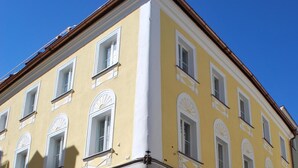 Un edificio amarillo con varias ventanas y un cartel que dice 