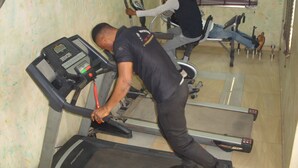 Een sportschool met loopbanden en fitnessapparatuur.