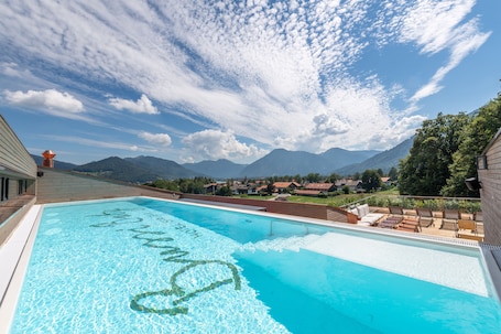 Una piscina al aire libre, sillones reclinables de piscina