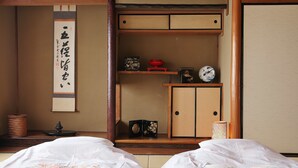Una habitación tradicional japonesa con suelo de tatami, un celosía de papel shoji y un futón.