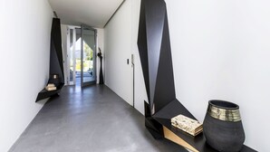 Un intérieur moderne au design épuré et minimaliste, agrémenté d’éléments géométriques noirs et d’un sol en béton.