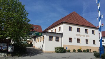 A building with a red roof and white walls, labeled "Landgasthof 2018".