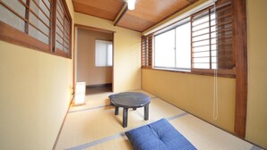 A traditional Japanese room with tatami flooring, a low wooden table, and shoji screens. - Kyoto House (Kyoto)